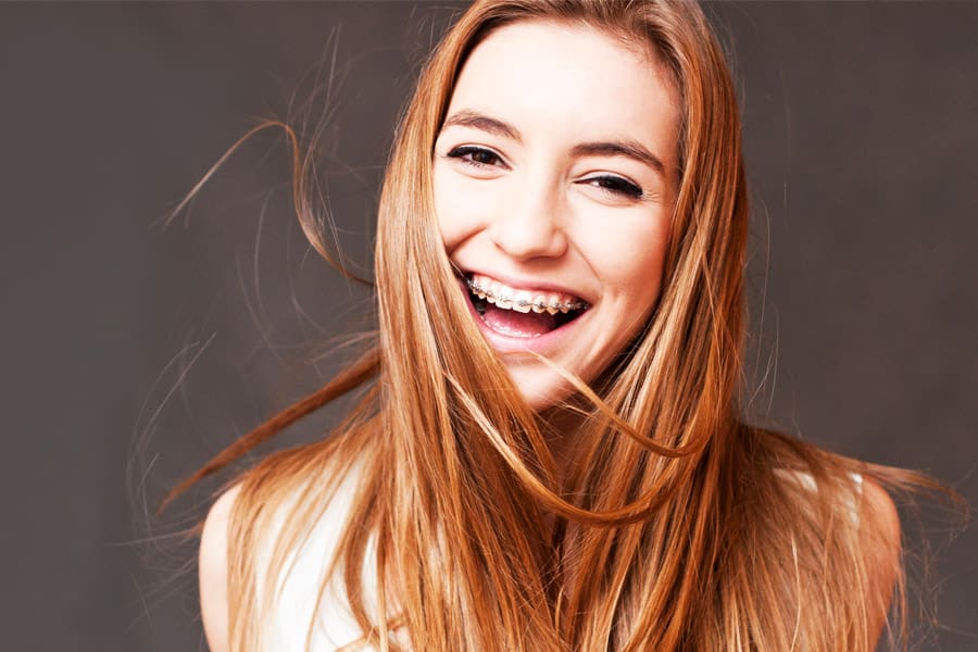 Smiling young adult girl with braces